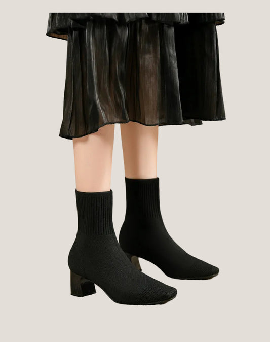 Bottines Margot noires portées avec une jupe plissée